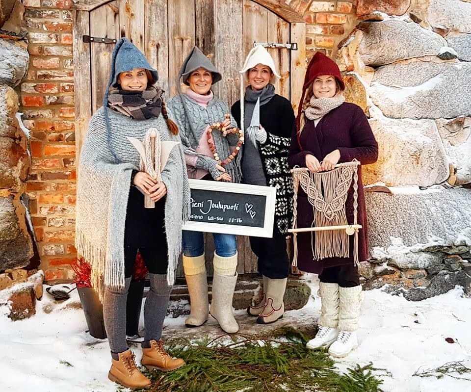 Vasemmalta Satu, Johanna, Heidi ja Saija Pienen Joulupuodin kivinavetan ovella talvella, käsissään omia käsitöitään